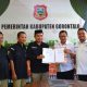 Kaban Keuangan dan Aset Daerah Kabupaten Gorontalo, Hariyanto Manan bersama Kaban Kesbangpol, Burhan Ismail saat foto bersama dengan penyelenggara pemilu seusai penandatangan berita acara penyesuaian anggaran untuk Pilkada 2024.