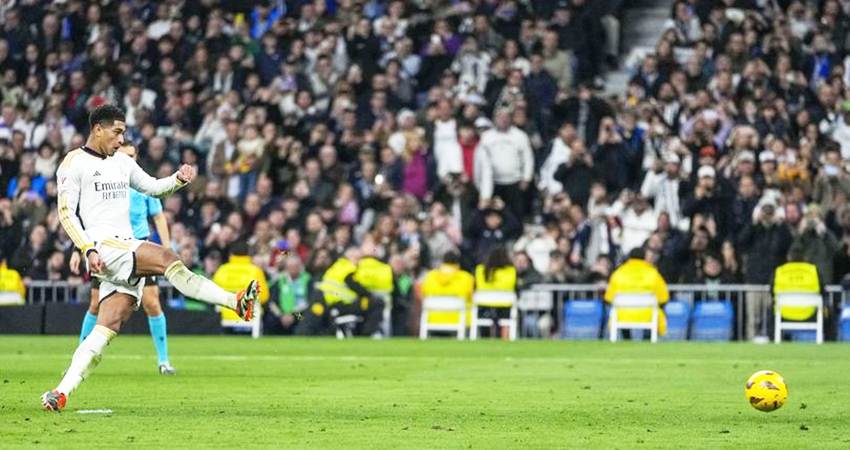 Jude Bellingham mengeksekusi penalti di laga Real Madrid vs Almeria di pekan ke 21 La Liga 2023/2024 di Santiago Bernabeu, Minggu (21/01/2024) malam WIB. (c) AP Photo/Bernat Armangue