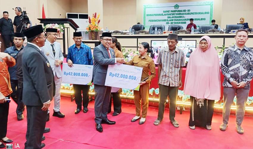 Ketua DPRD Boalemo, Karyawan Eka Putra Noho ketika menyerahkan secara simbolis bantuan kepada para mustahiq yang dihadirkan pada sidang paripurna dalam rangka HUT ke-26 Kabupaten Boalemo.