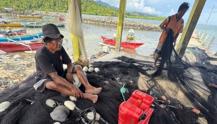 SIAP MELAUT – Takim Patta dan rekannya sesama nelayan mempersiakan jaring, dan BBM untuk melaut menangkap ikan sagela di laut Teluk Tomini, Ahad (31/5) siang. (Foto: Jitro Paputungan /Hargo.co.id)