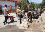 Brimob dan Warga Isimu Raya Gotong Royong Perbaiki Jalan Rusak