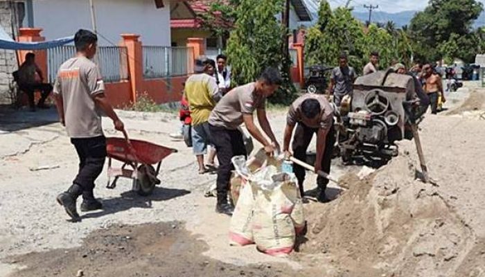 Brimob dan Warga Isimu Raya Gotong Royong Perbaiki Jalan Rusak